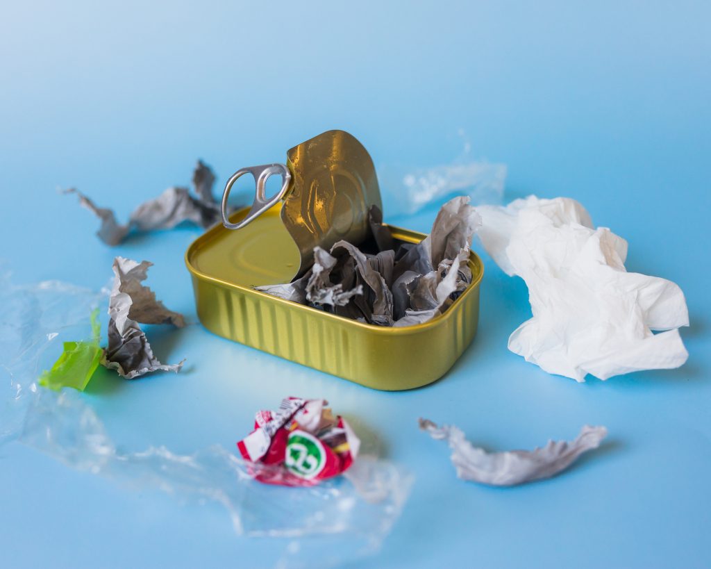 Mixed waste including plastic, paper, and metal packaging highlighting environmental pollution